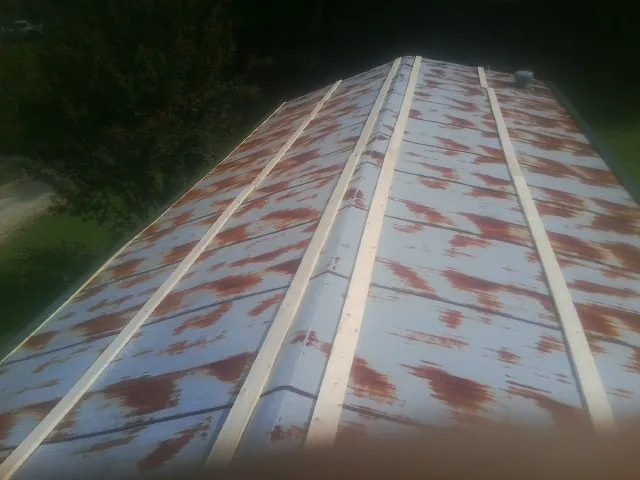 Rusted metal roof panels with new wood purlins before replacement — Storm Damage Roof Repair in Home by Roofing Brothers