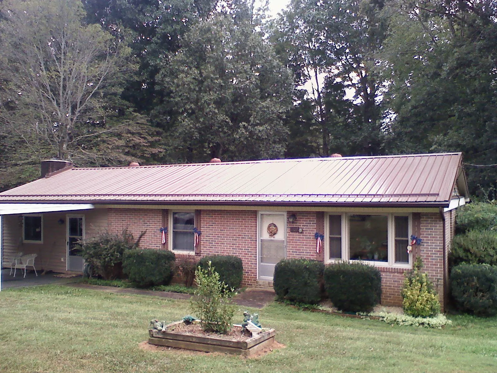 Bronze metal roof on a brick ranch home with a carport in Home
