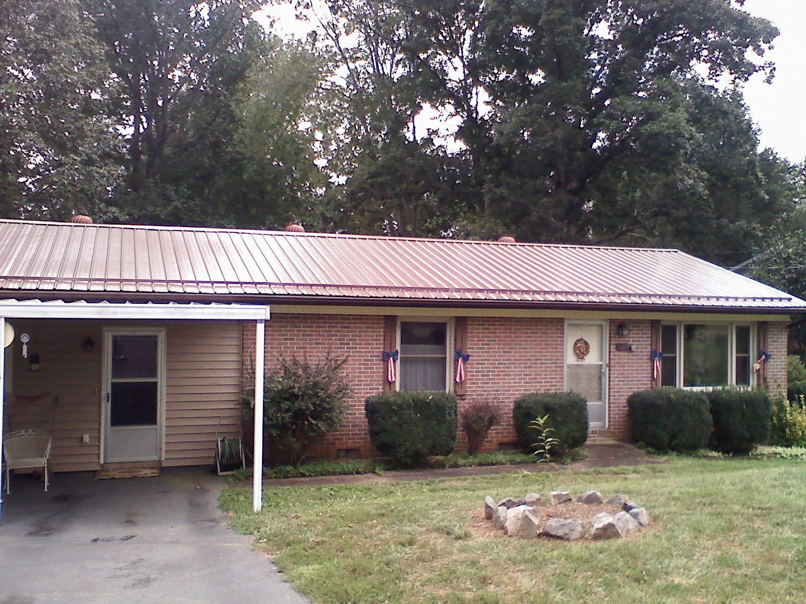 Bronze metal roof and carport on a brick ranch home — Roof Repair work by our crew in Home